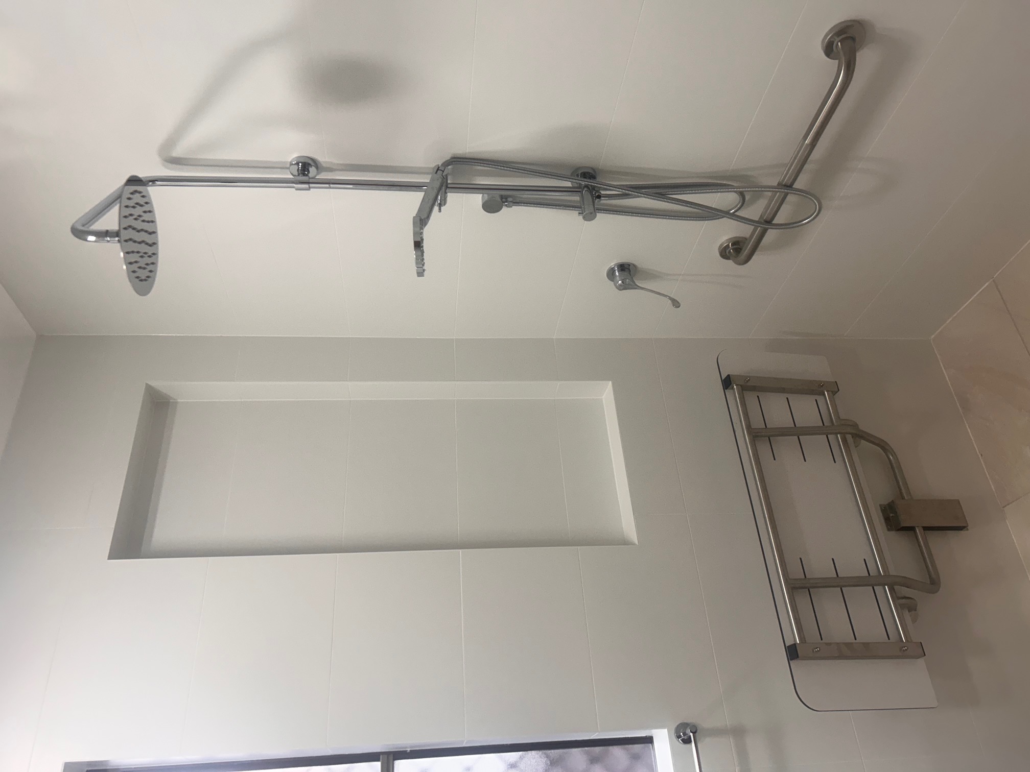Accessible bathroom with rain shower, fold-down seat and grab rails