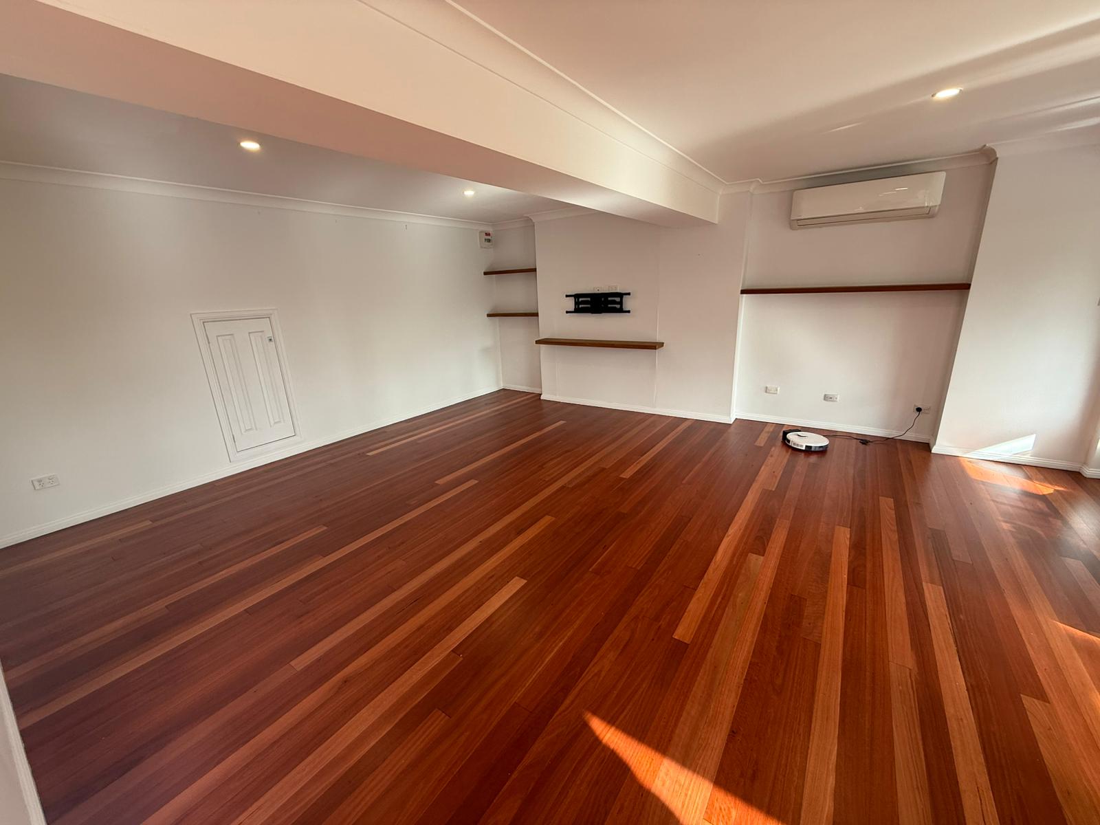 Freshly renovated room with polished hardwood floors and recessed lighting