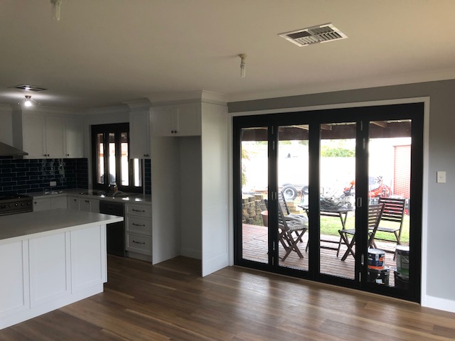 Renovated open-plan kitchen and living area with bifold doors to the deck